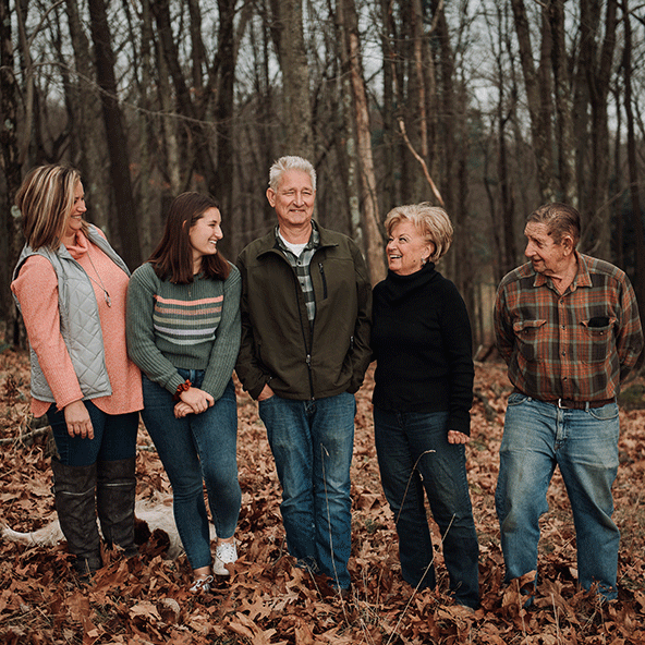 A multi-generational family of NCX landowners stand together in their forest
